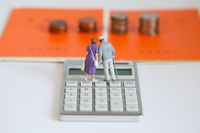 2 kleine Figuren stehen auf einem Taschenrechner