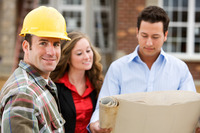 Ein Handwerker mit einem Helm, eine Frau und ein Mann mit einem Bauplan. Das Bild zeigt einen Handwerker mit einem Helm, eine Frau und ein Mann mit einem Bauplan.