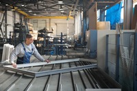 Ein Handwerker, der einen Fensterrahmen bearbeitet. Das Bild zeigt einen Handwerker, der einen Fensterrahmen bearbeitet.