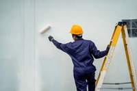 Maler streicht eine Hauswand